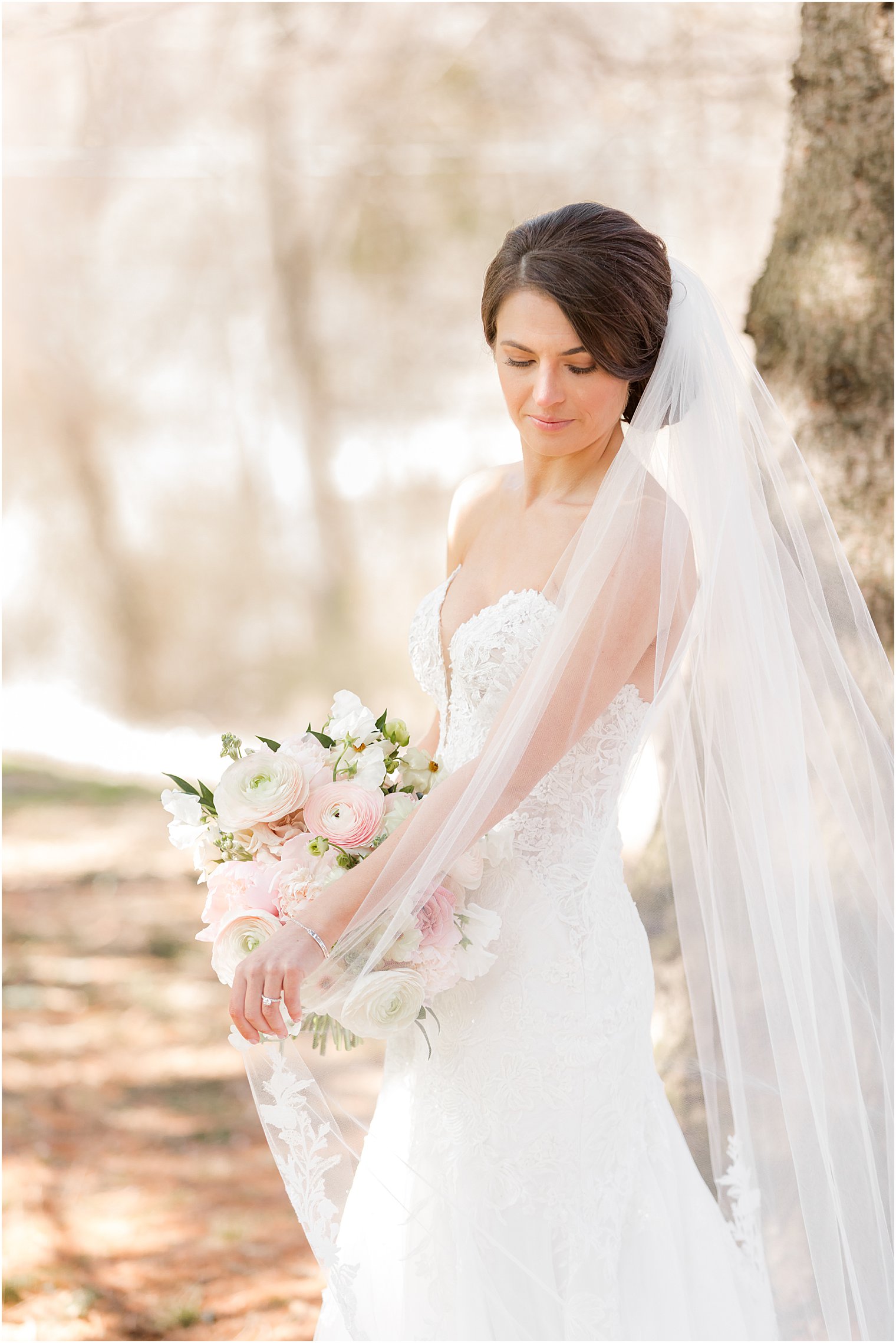 bride holds pastel bouquet from Peonies to Paint Chips in front of stomach