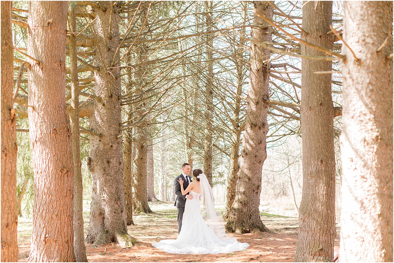 couple stands together in woods at The Refinery at Perona Farms