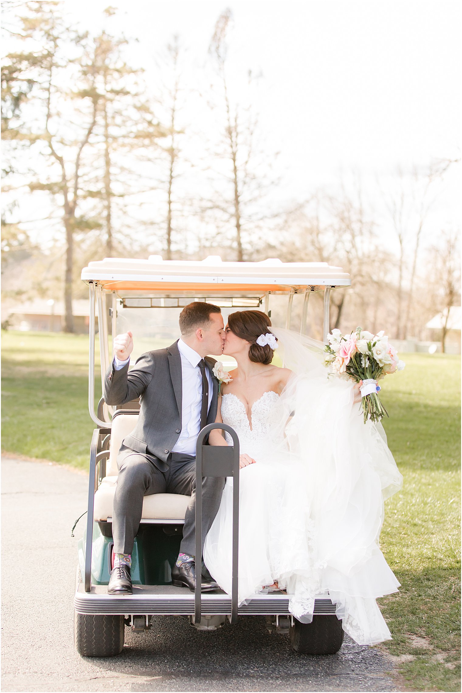 couple kisses on golf cart at The Refinery at Perona Farms