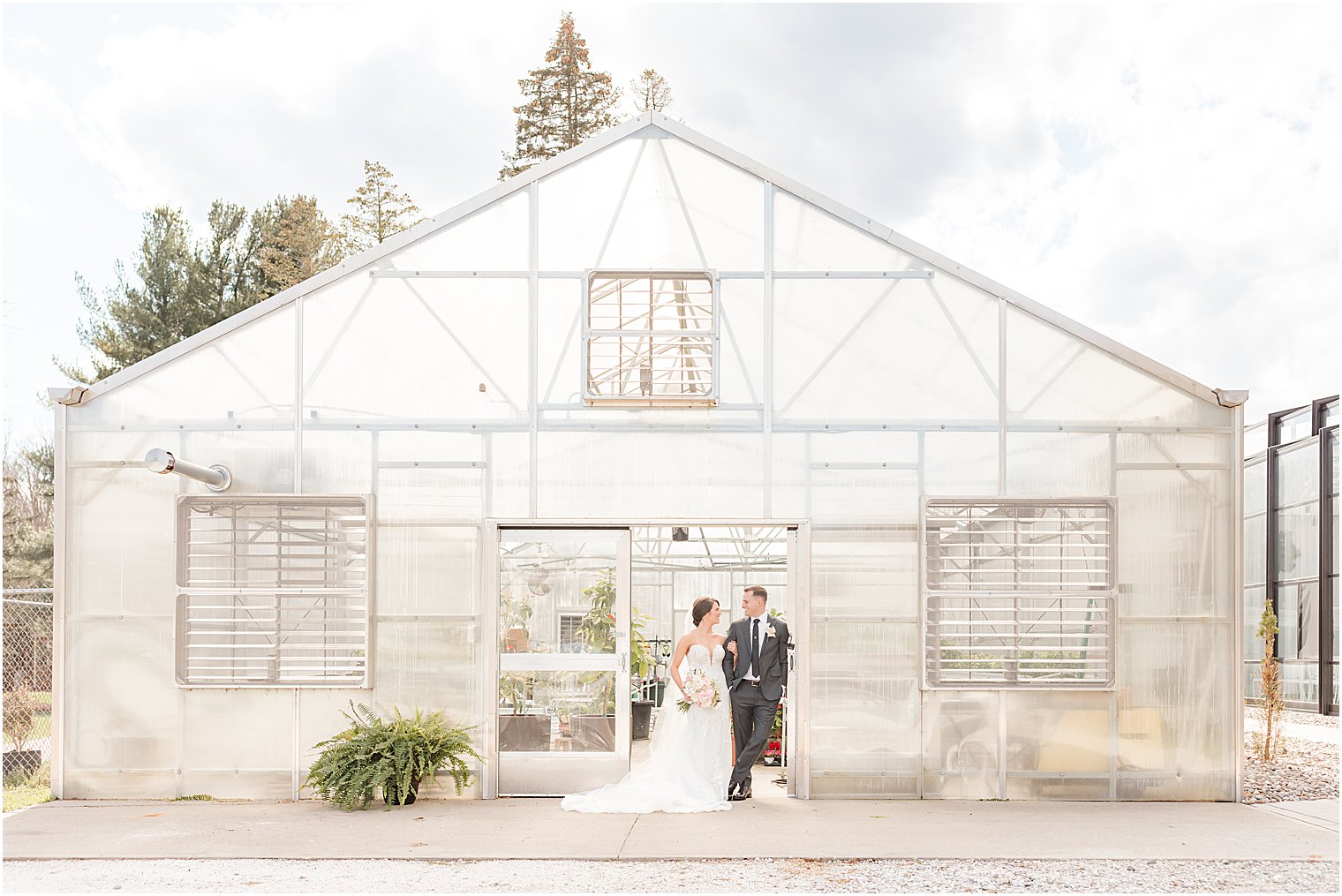 bride and groom stand outside of greenhouse in Andover NJ