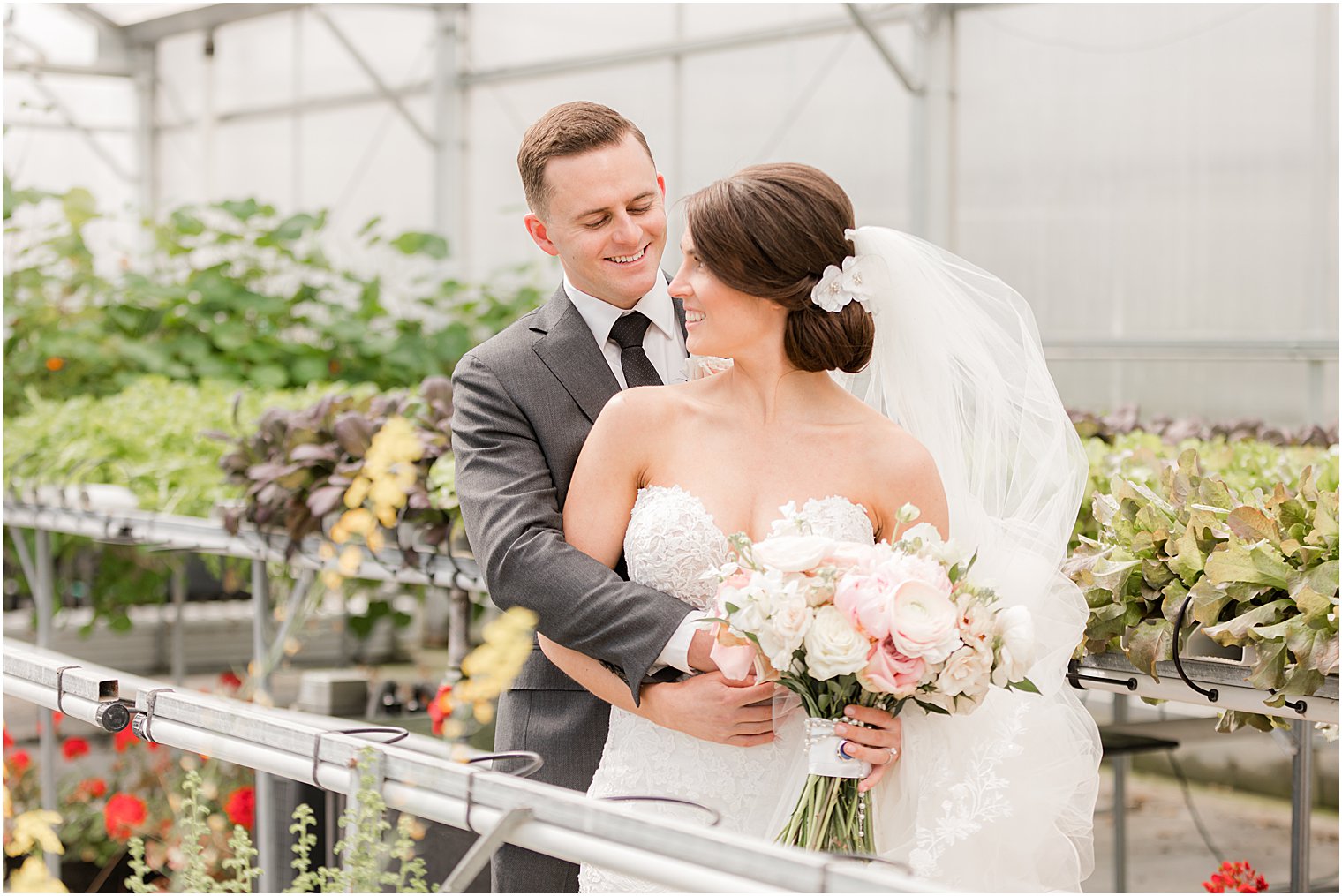bride and groom hug inside greenhouse