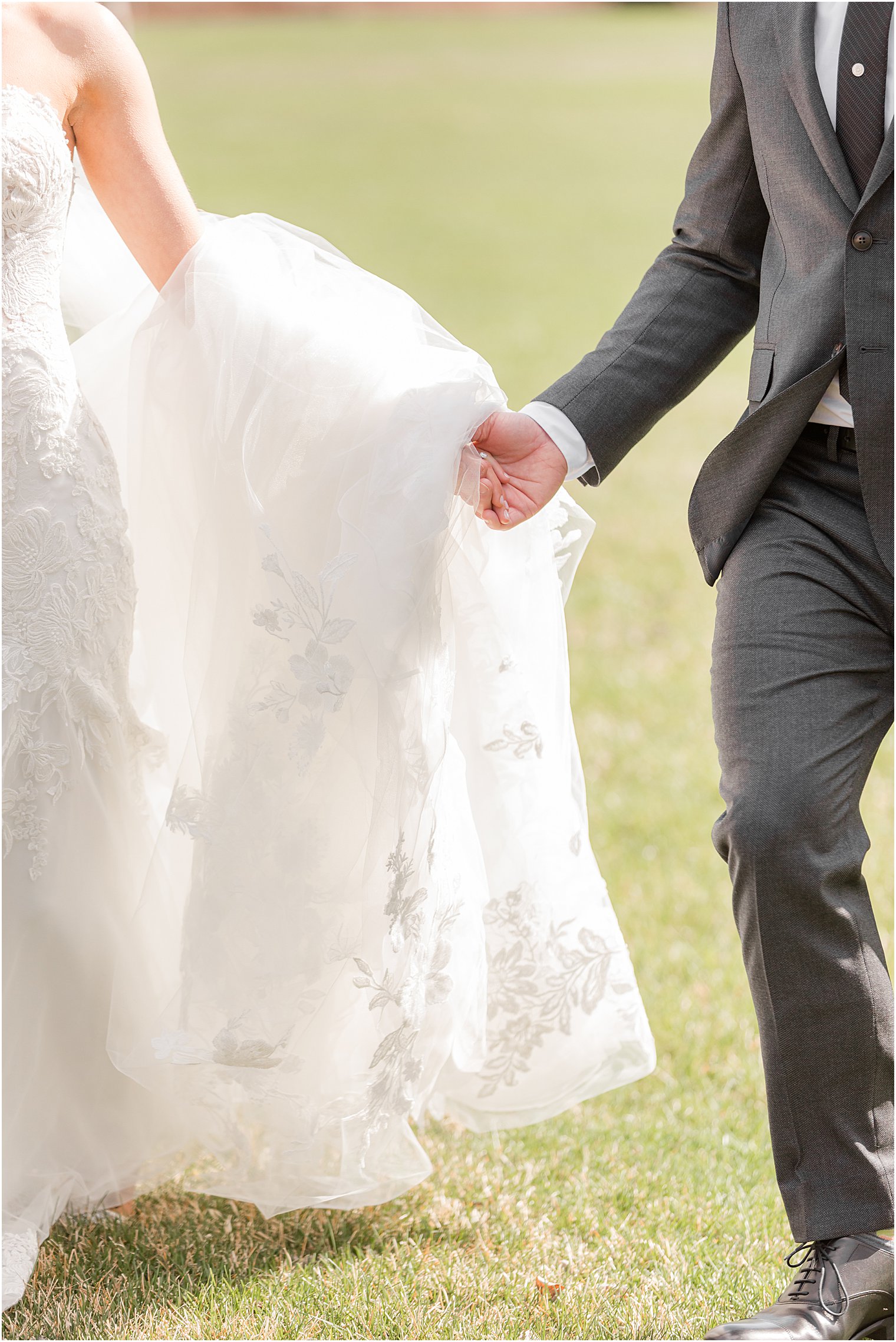 bride and groom hold hands walking