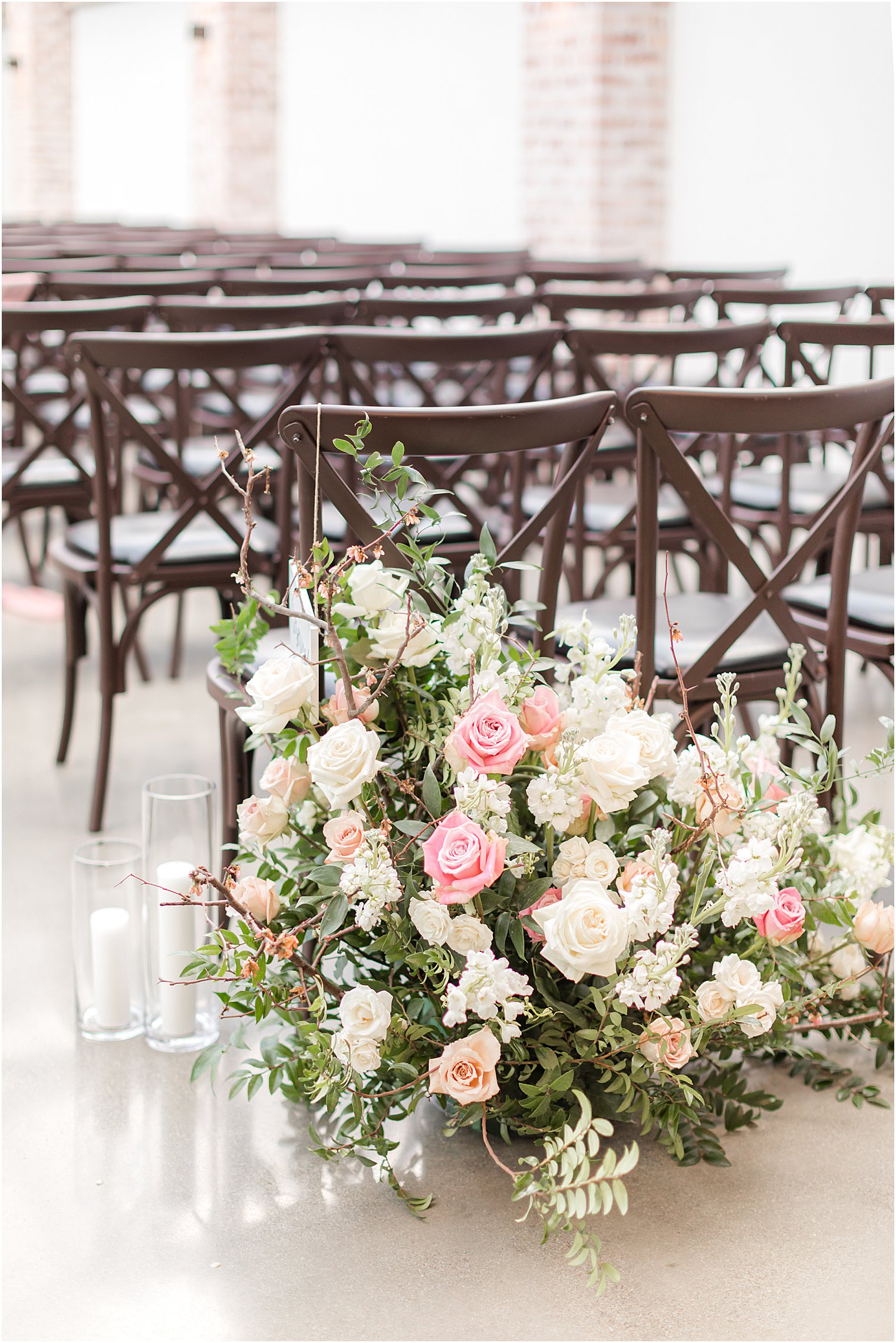 brown wood chairs and floral display at The Refinery at Perona Farms ceremony