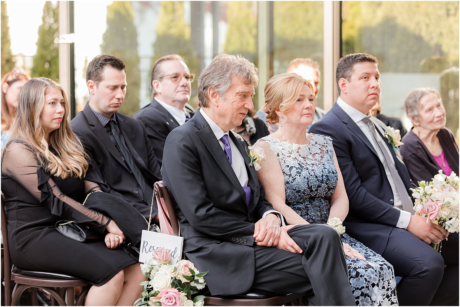 parents sit in courtyard during wedding ceremony