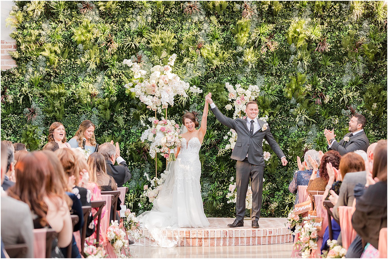 bride and groom cheer after outdoor wedding ceremony in courtyard