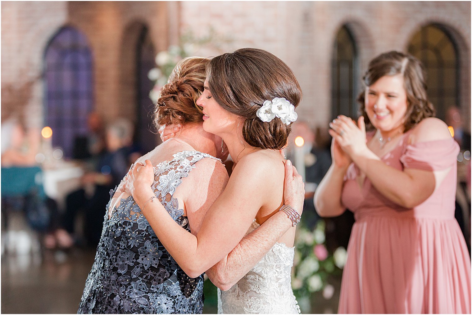 mom hugs bride during wedding reception 