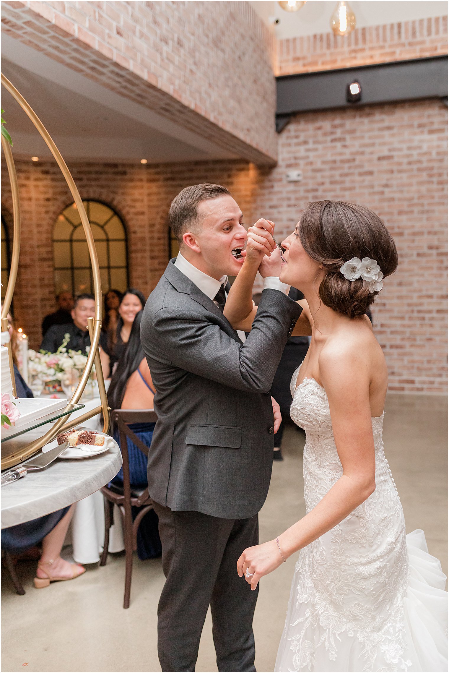 couple eats wedding cake with linked arms