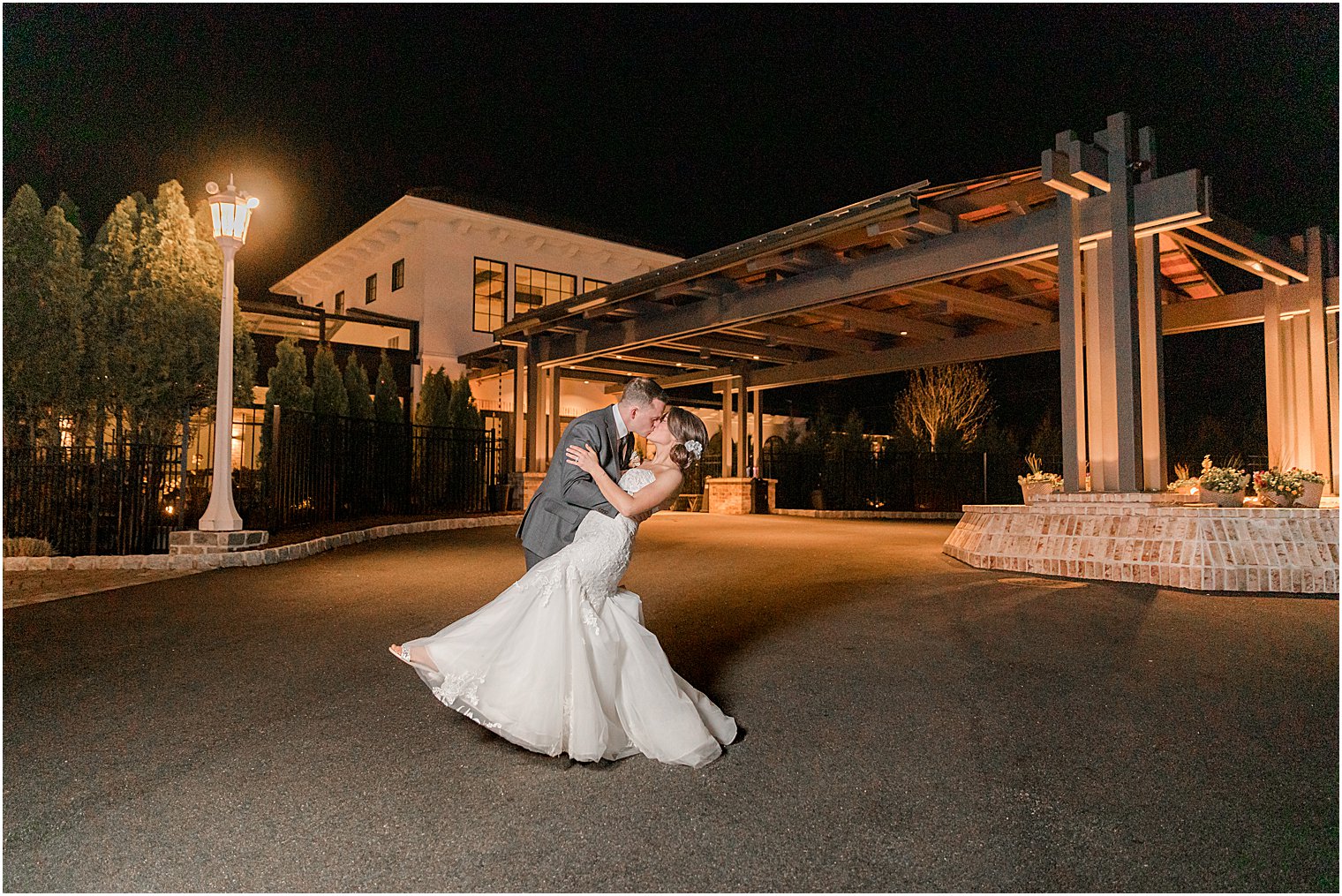 bride and groom kiss during nighttime wedding portraits at The Refinery at Perona Farms