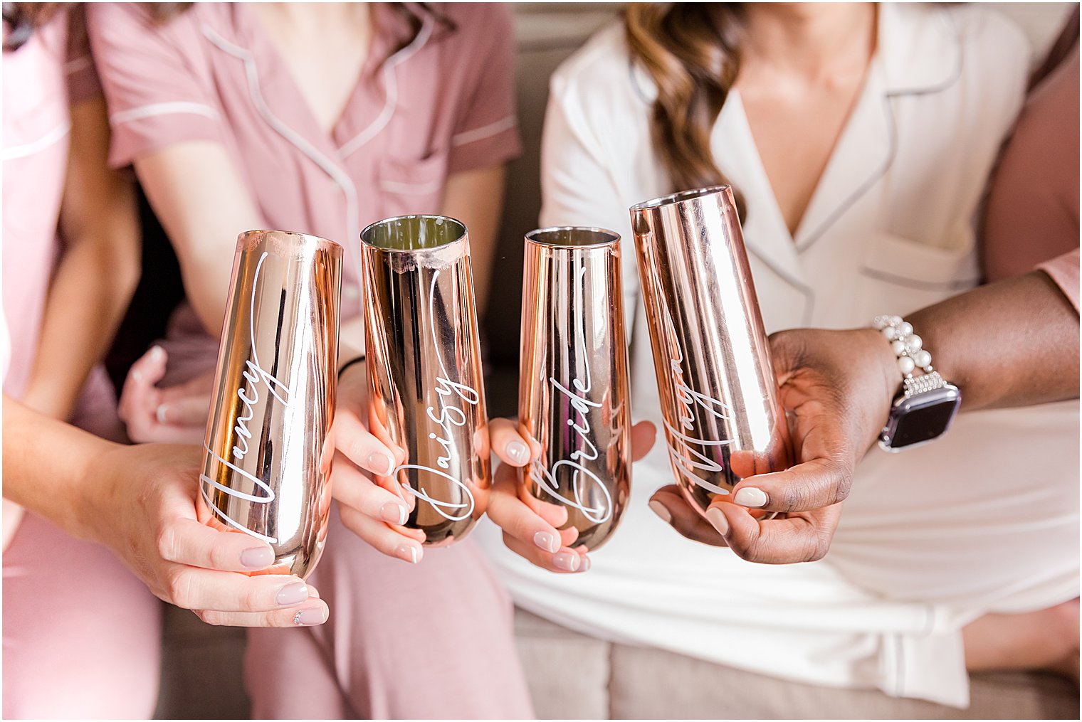 bride and bridesmaids toast champagne with custom tumblers