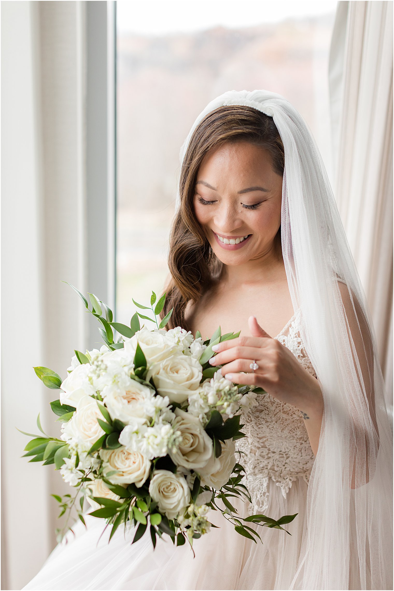 New Jersey bride looks down at bouquet of white roses