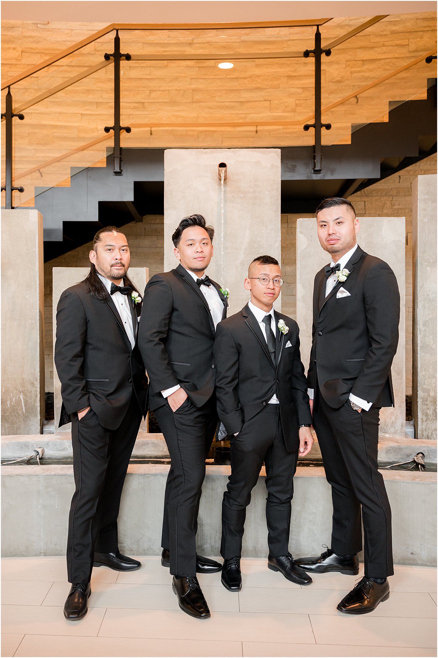 groom stands with groomsmen inside The Lodge at Stirling Ridge