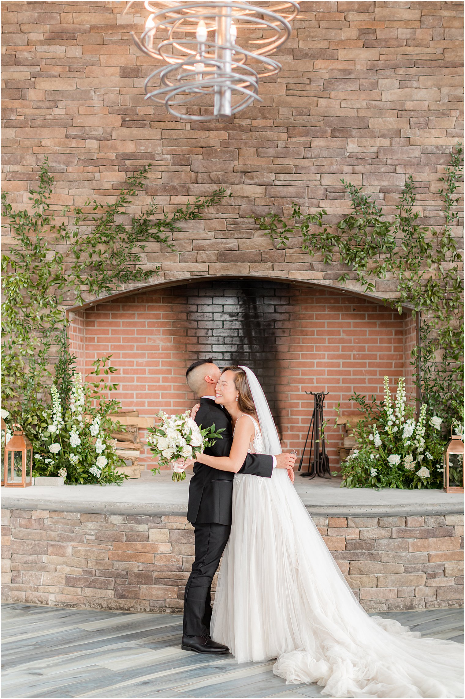 couple hugs by stone fireplace at The Lodge at Stirling Ridge
