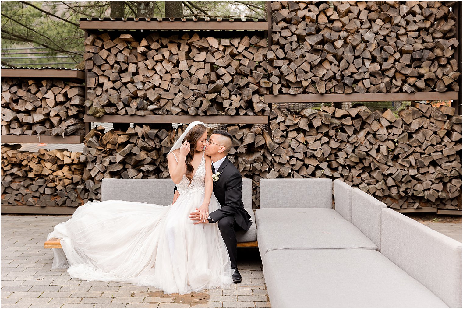 couple sits on sofa outside by woodpile at The Lodge at Stirling Ridge