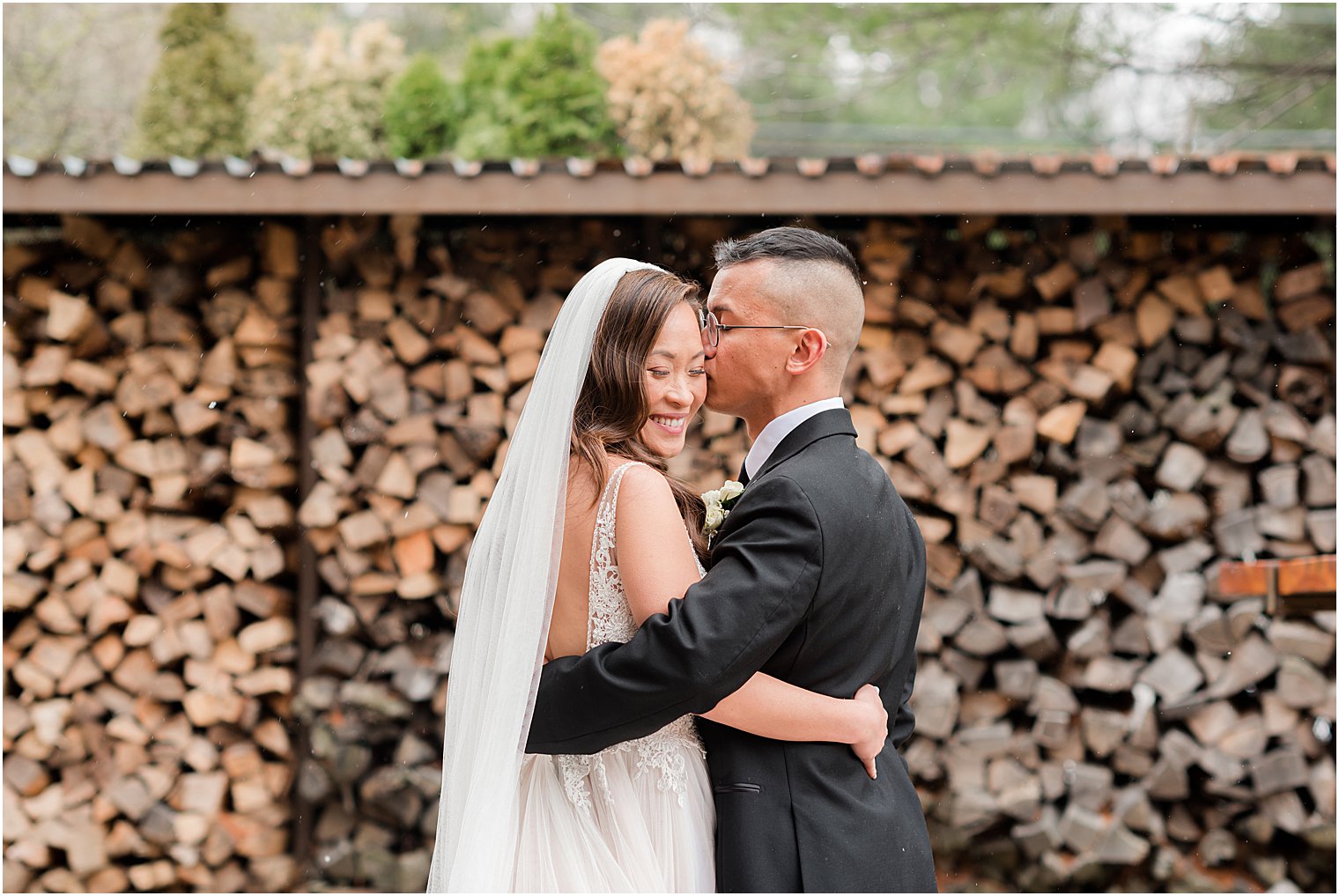 groom kisses bride's forehead during NJ wedding portraits 