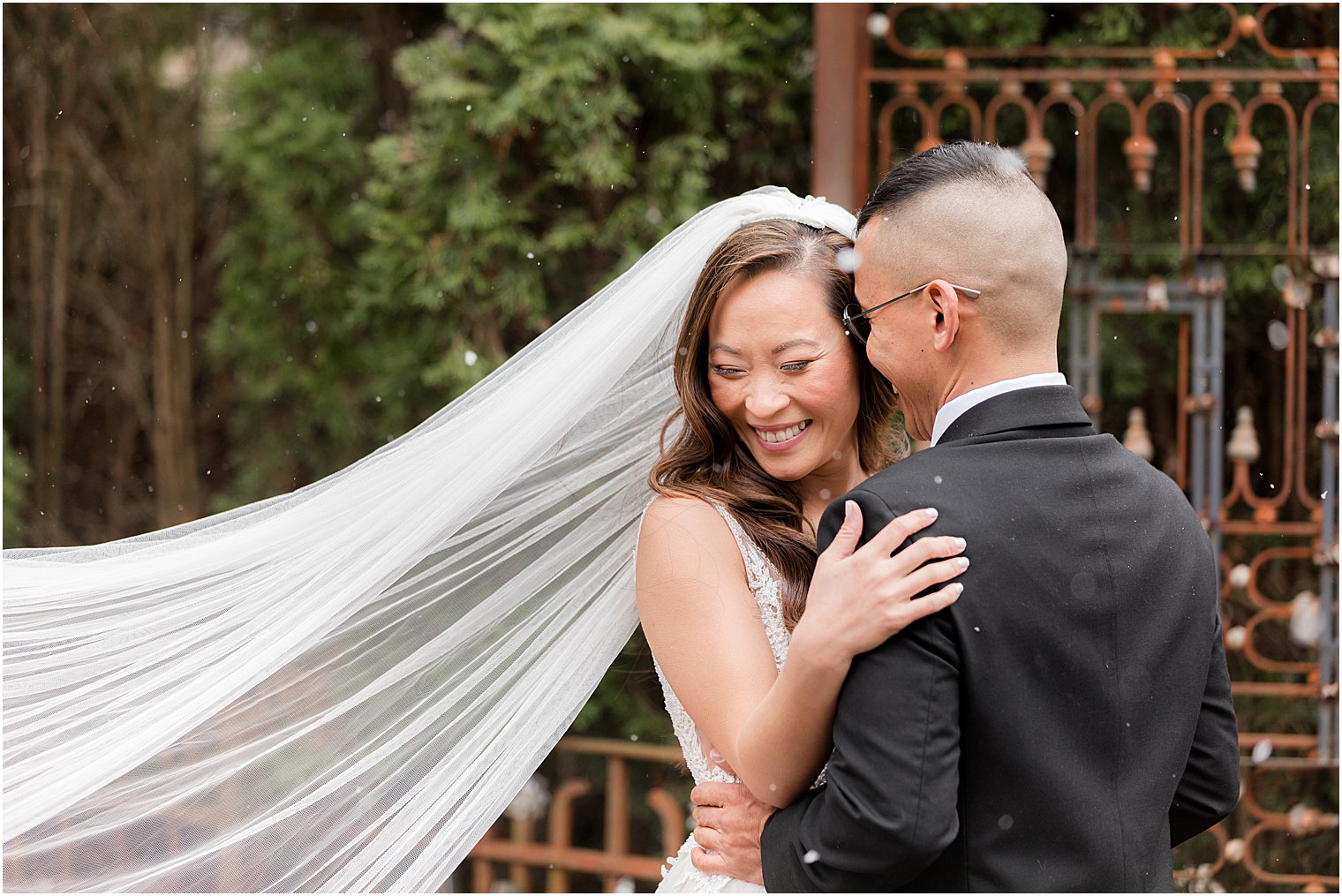 groom nuzzles bride's cheek during portraits on patio