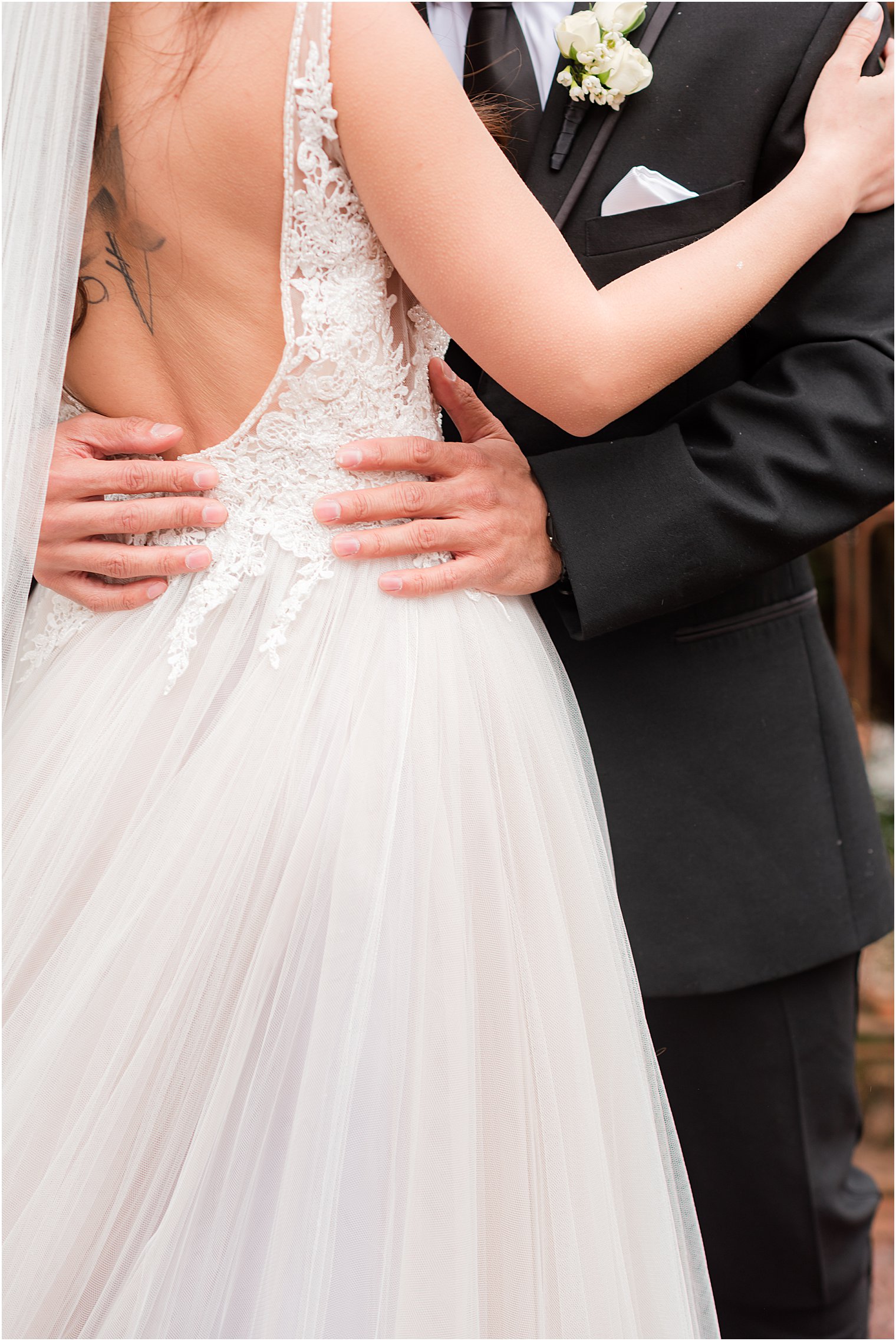 groom holds bride's hip during NJ wedding photos