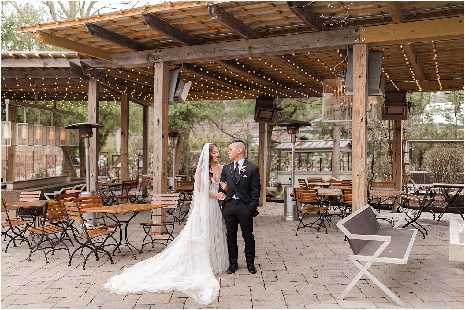 bride and groom stand on outdoor patio