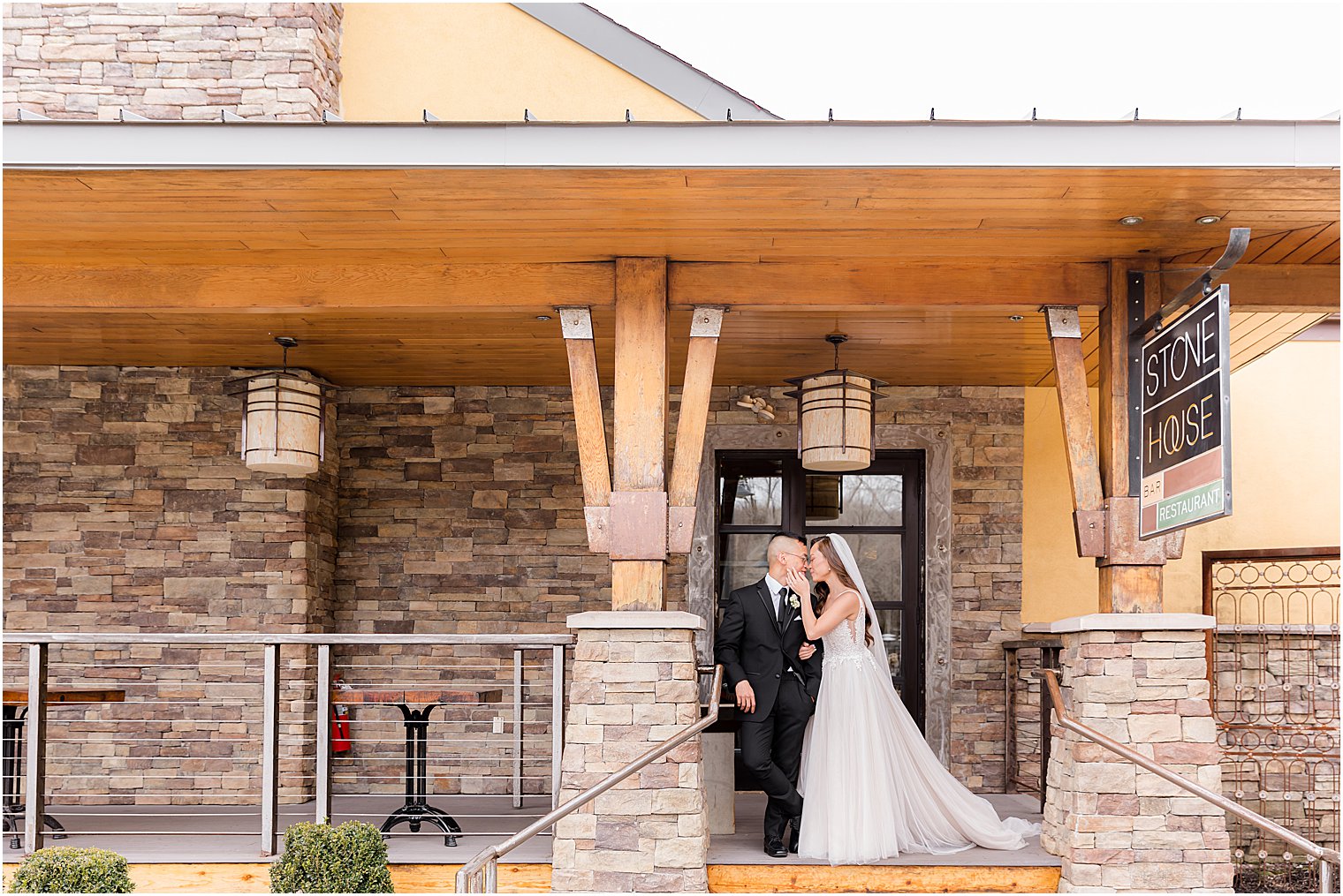 newlyweds pose on front porch at The Lodge at Stirling Ridge