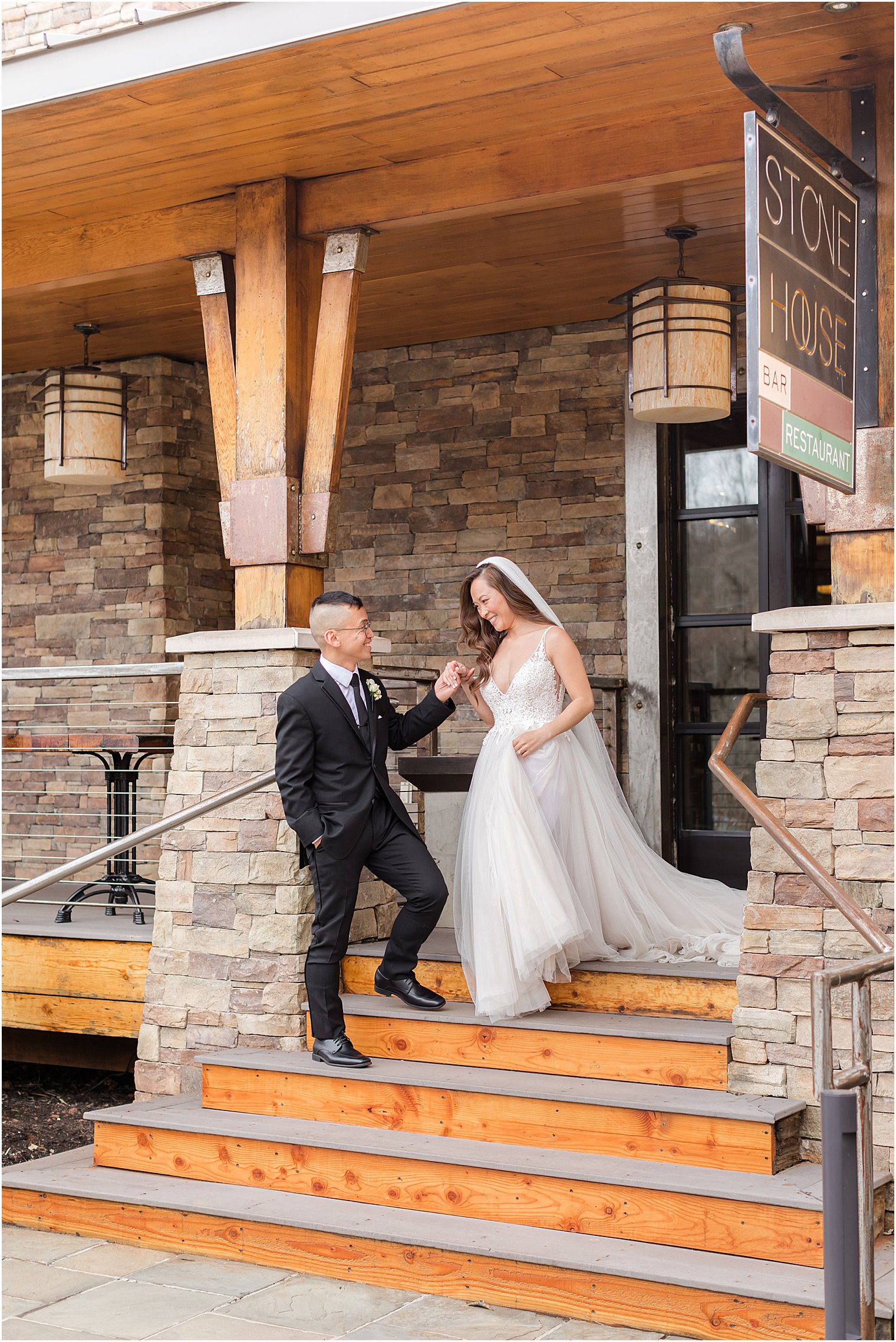 groom helps bride down steps at The Lodge at Stirling Ridge