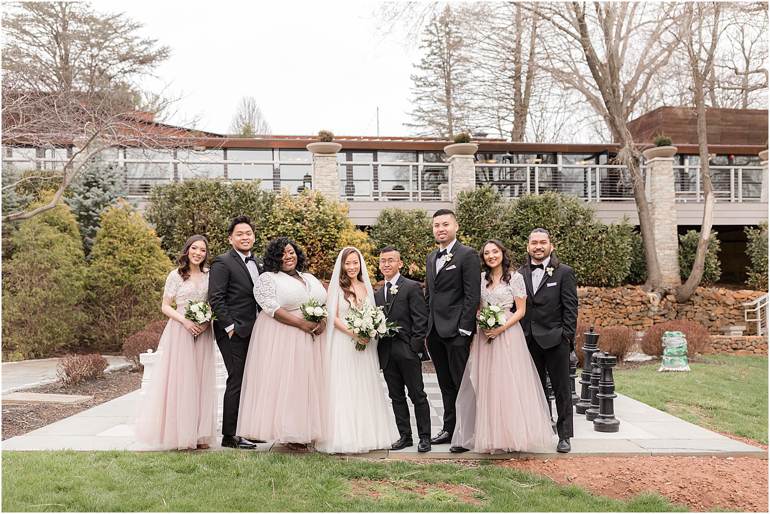 newlyweds pose with wedding party in pink and black