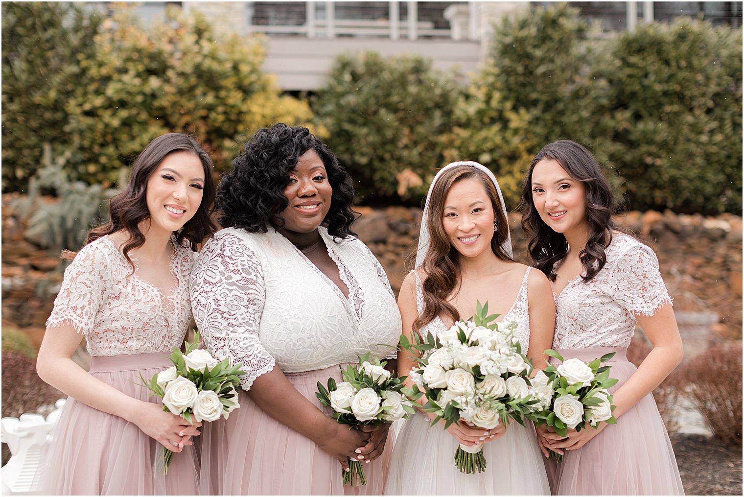 bride and bridesmaids pose together in pink gowns
