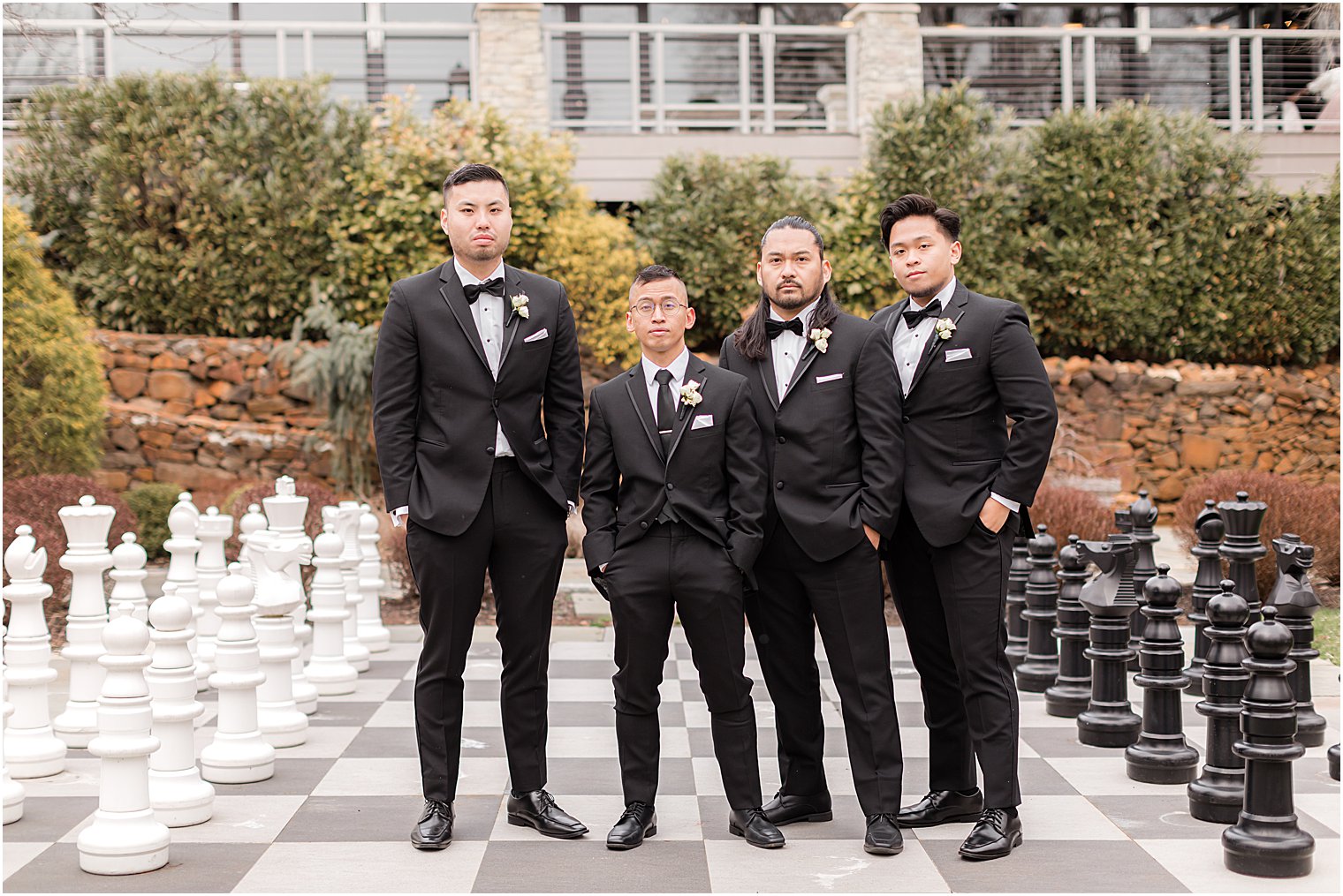 groom and groomsmen stand together on outdoor chess board