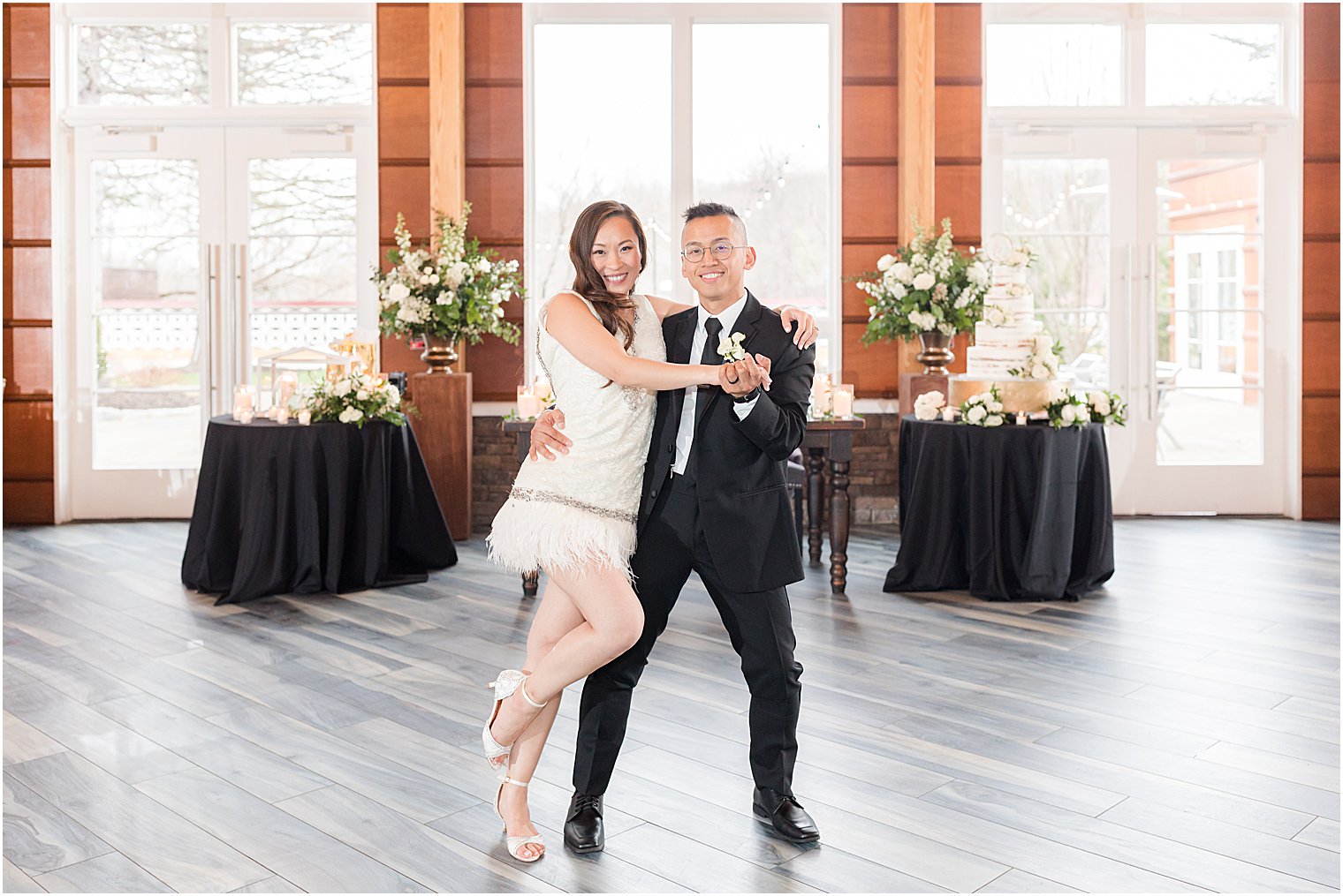 bride leans on groom's leg in fringed dress