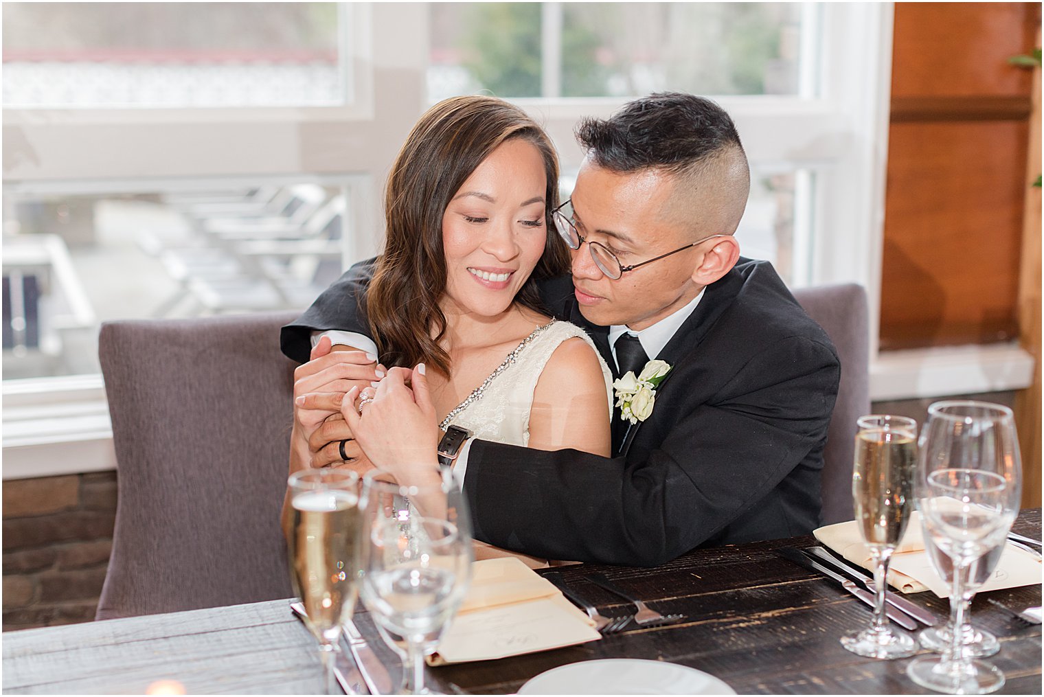 groom hugs bride during wedding reception at The Lodge at Stirling Ridge