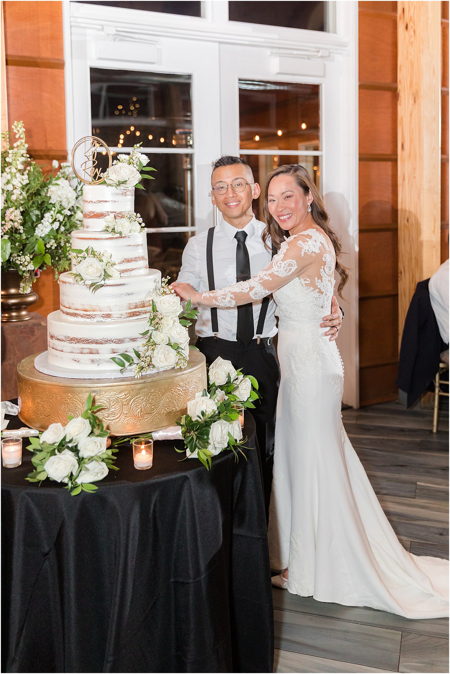 couple cuts wedding cake at wedding reception