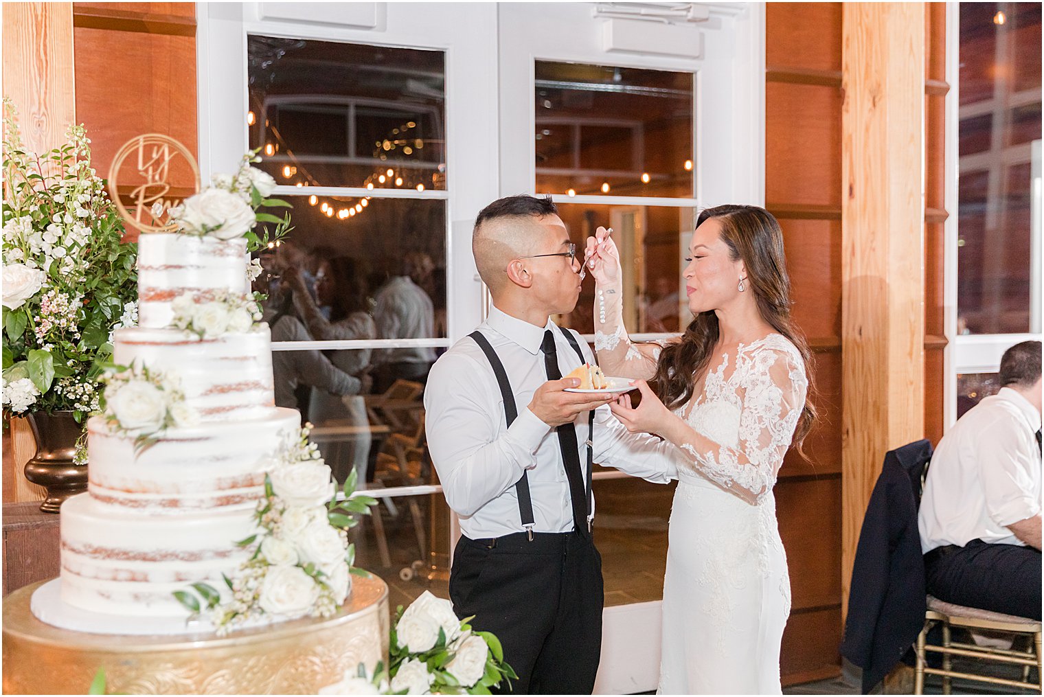 couple cuts wedding cake at wedding reception