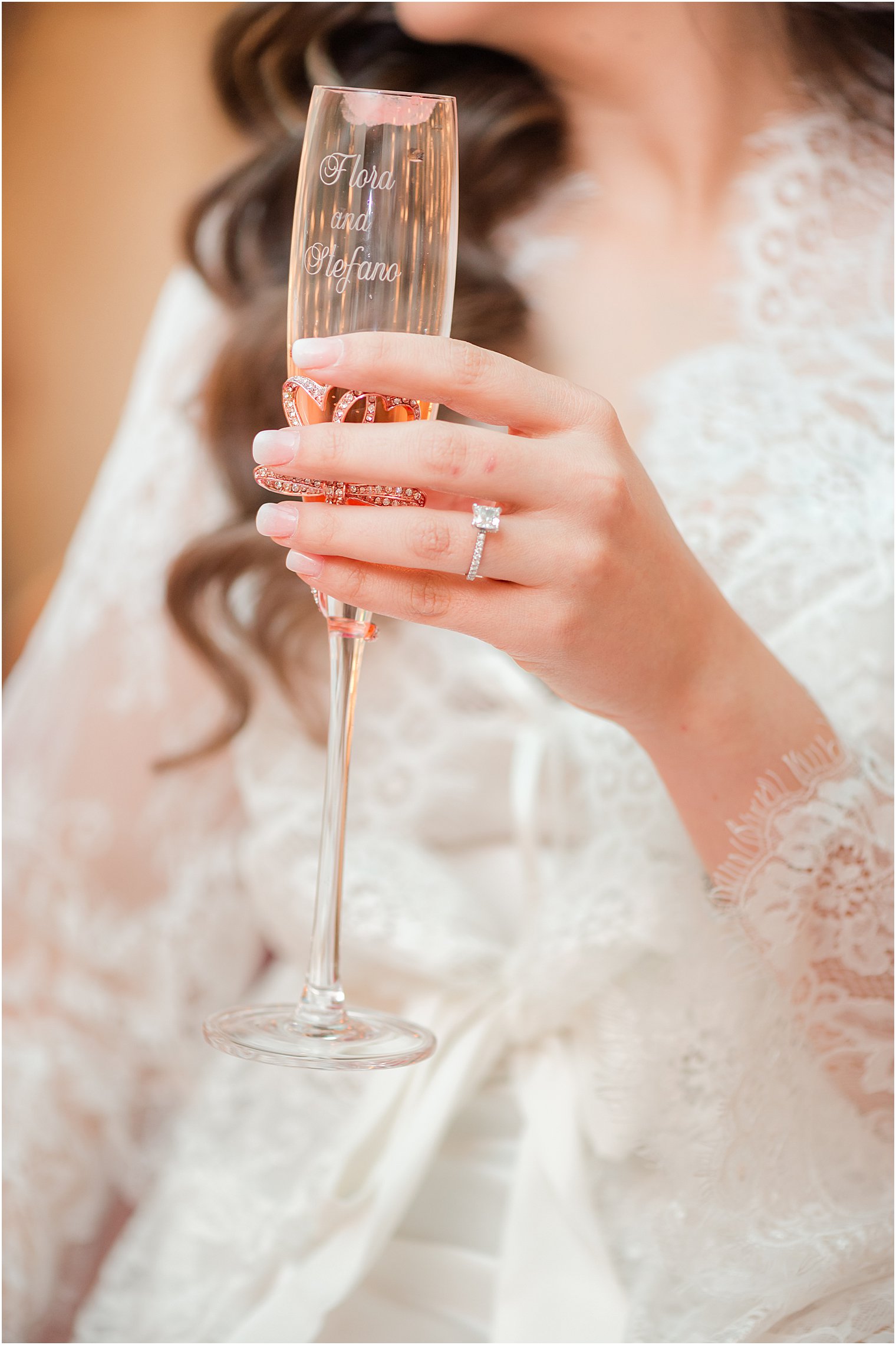 bride holds glass of champagne showing off ring