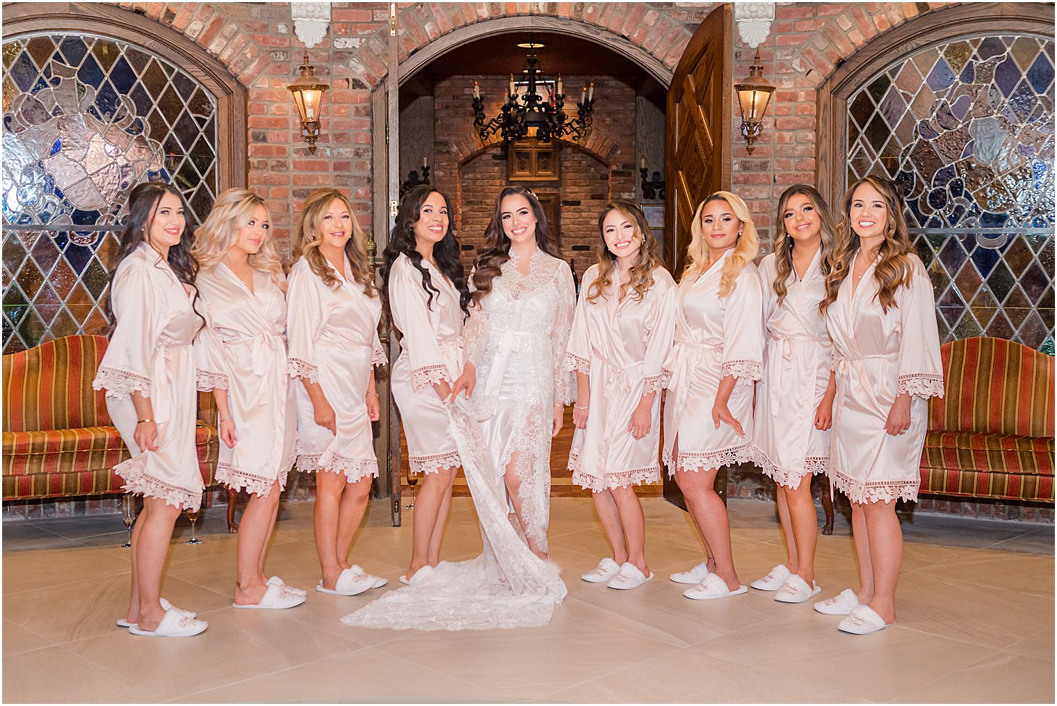 bride stands in hallway at The Manor with bridesmaids in matching pajamas 