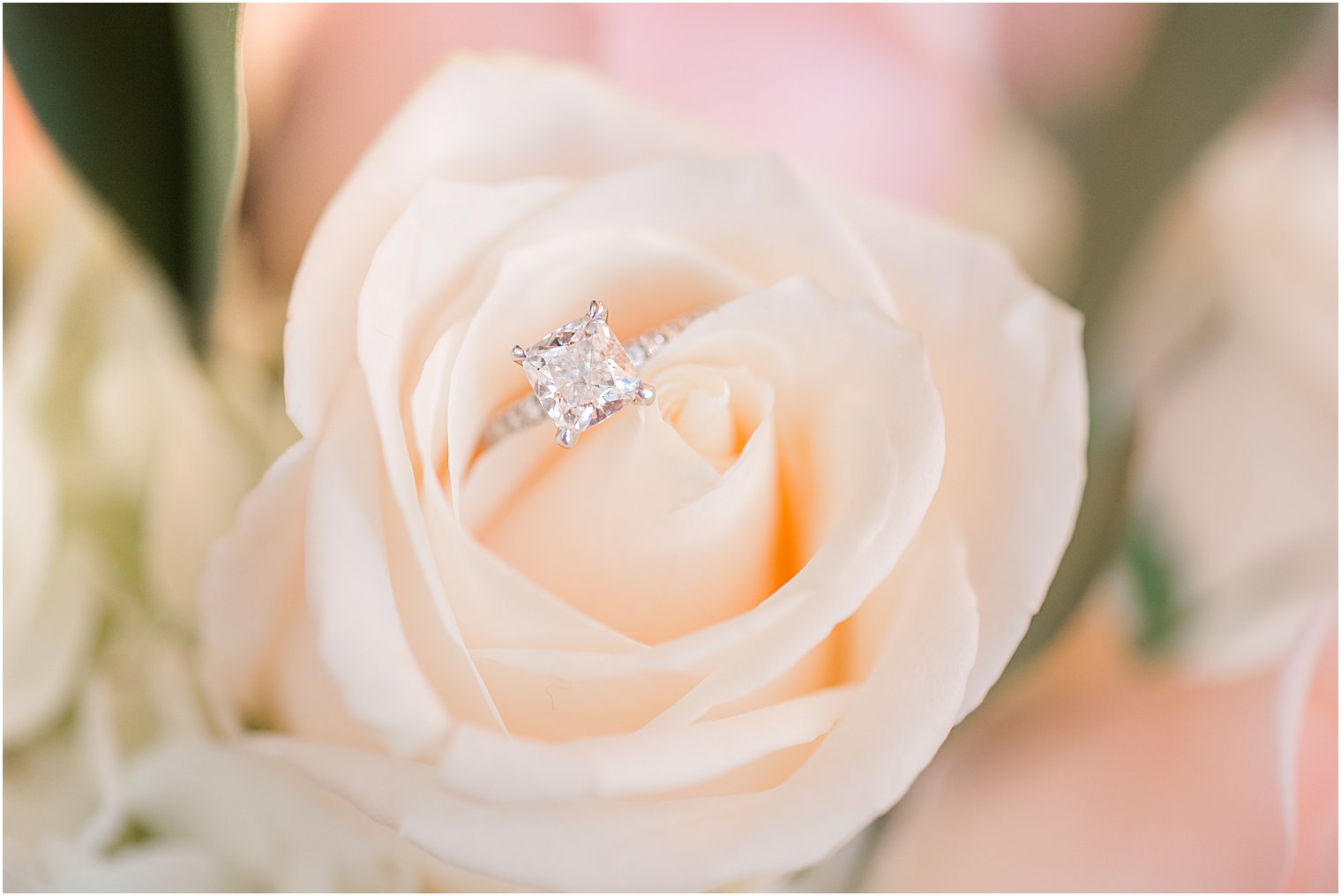 wedding ring rests in ivory rose during prep at The Manor