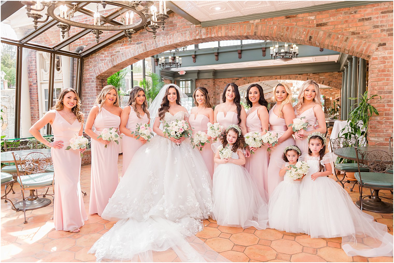 bride in princess skirt wedding gown poses with bridesmaids at The Manor