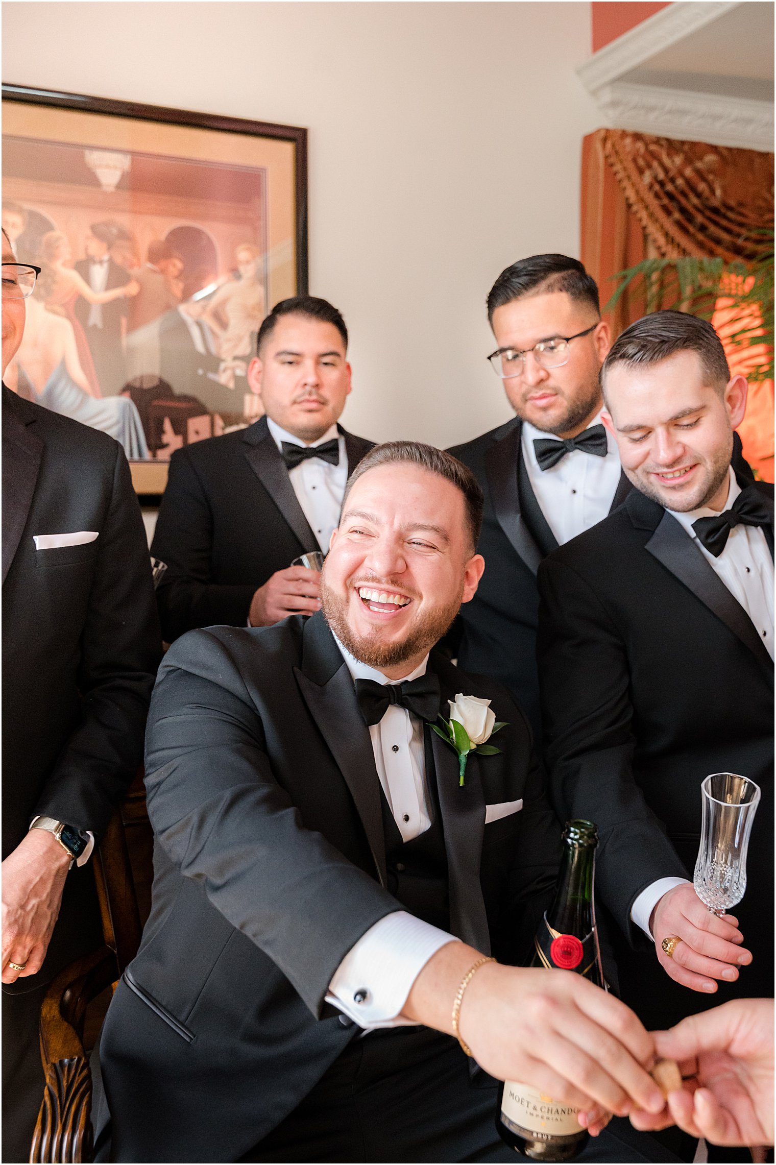 groom laughs with groomsmen before NJ wedding