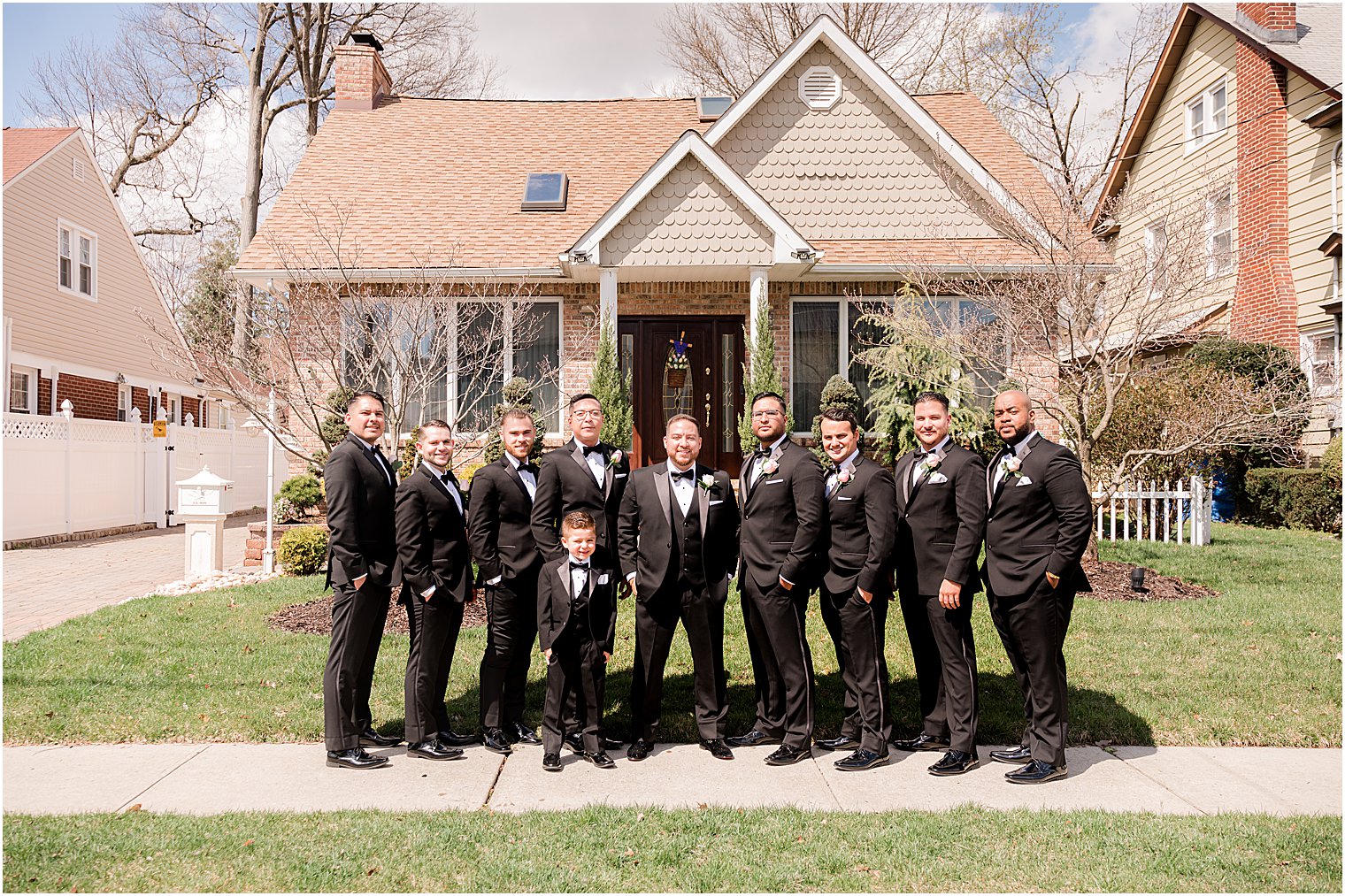 groom and groomsmen pose outside NJ home