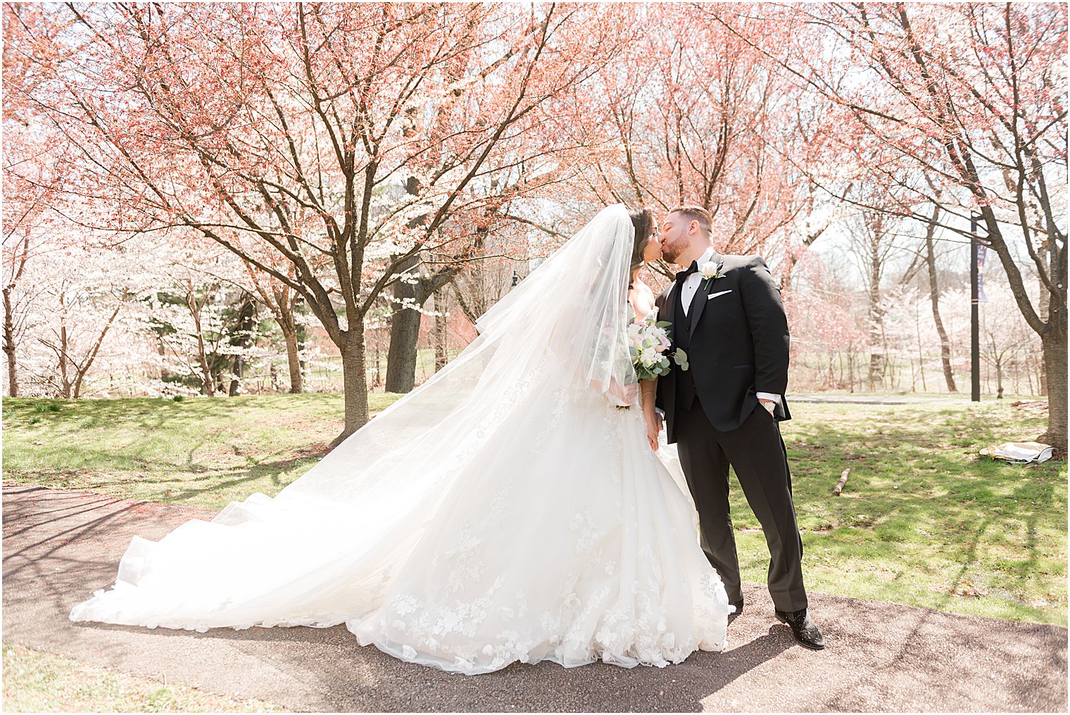 bride and groom kiss under cherry blossoms 