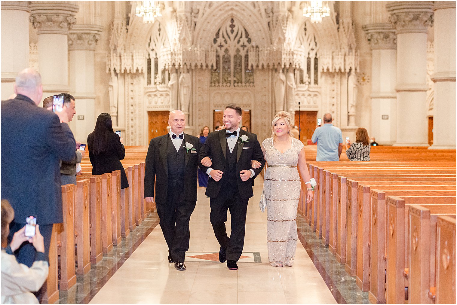 groom walks down aisle with parents for Catholic wedding ceremony at Cathedral Basilica of the Sacred Heart