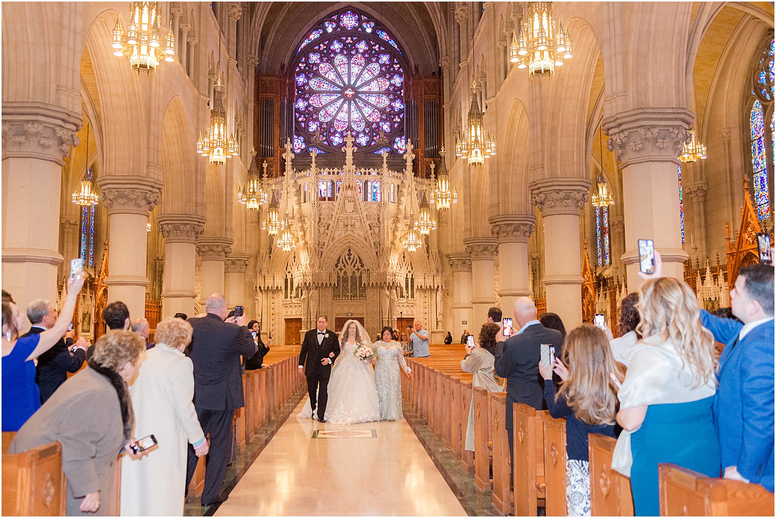 bride walks down aisle with parents during Catholic wedding ceremony at Cathedral Basilica of the Sacred Heart