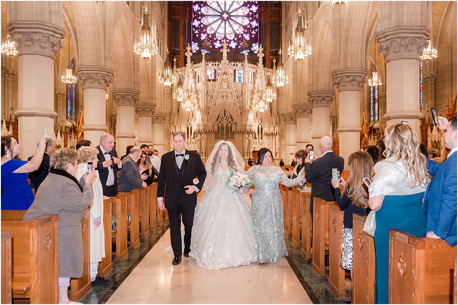 parents walk bride down aisle during Catholic wedding ceremony at Cathedral Basilica of the Sacred Heart