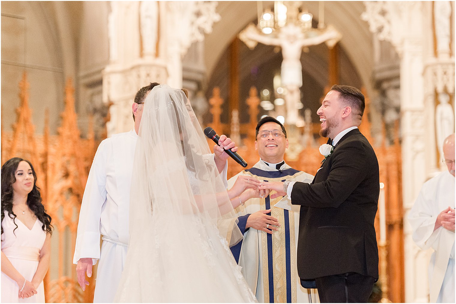 groom laughs during Catholic wedding ceremony at Cathedral Basilica of the Sacred Heart