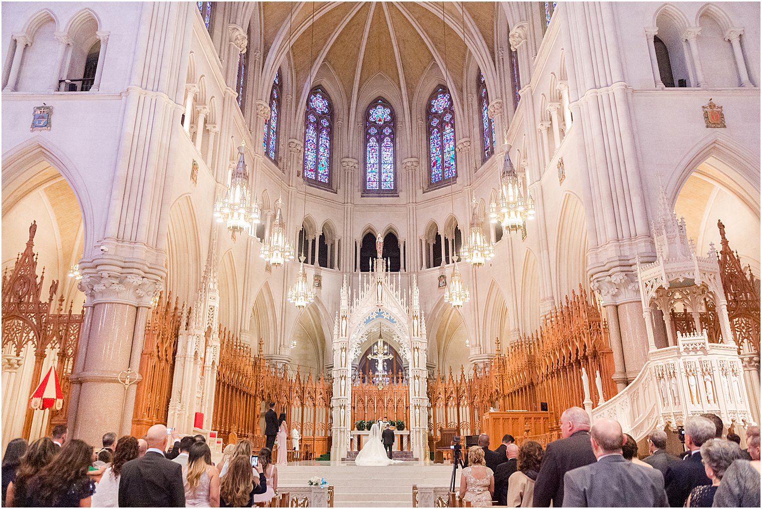 bride and groom kneel during Catholic wedding ceremony at Cathedral Basilica of the Sacred Heart