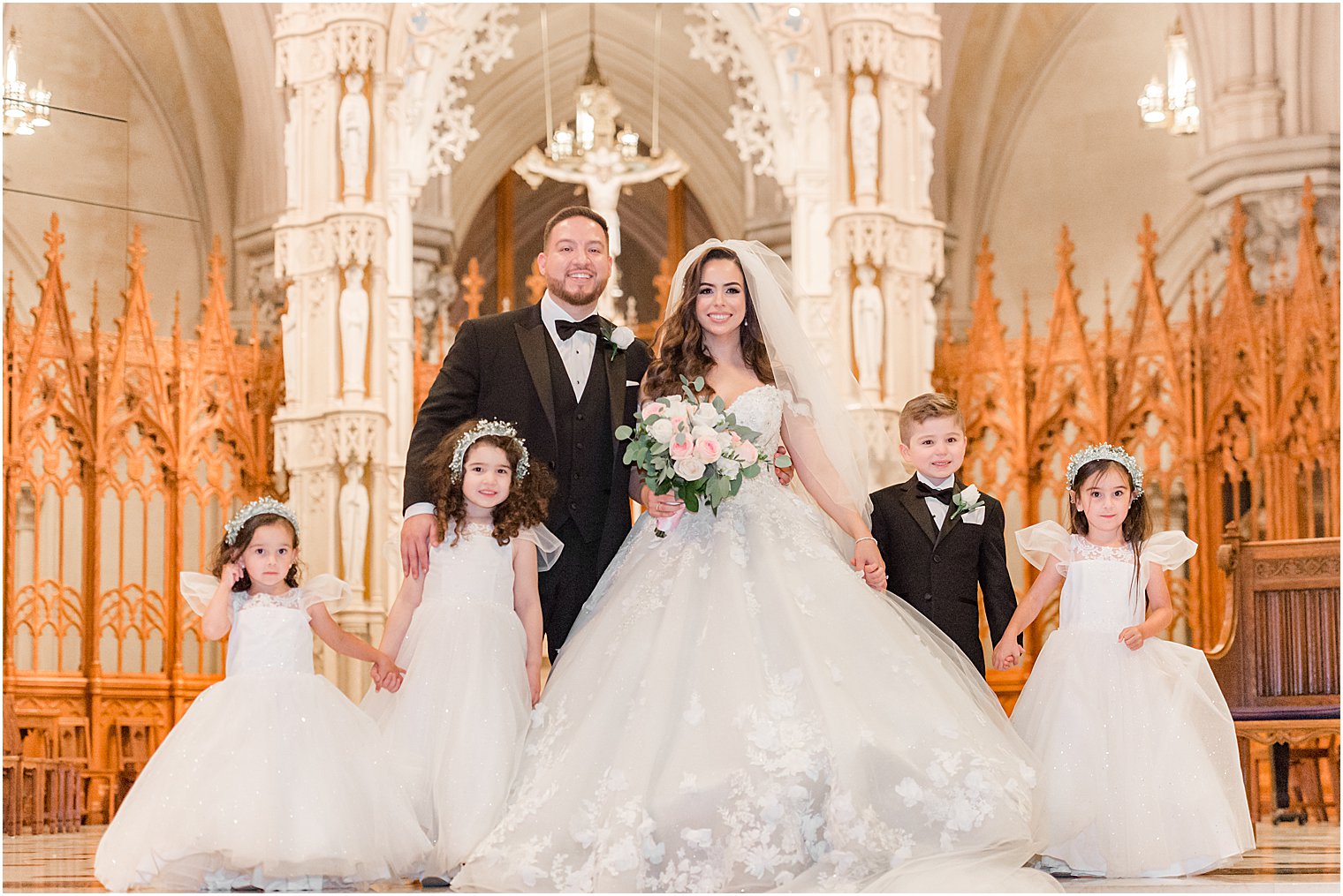 bride and groom stand with flower girls and ring bearer inside the Cathedral Basilica of the Sacred Heart