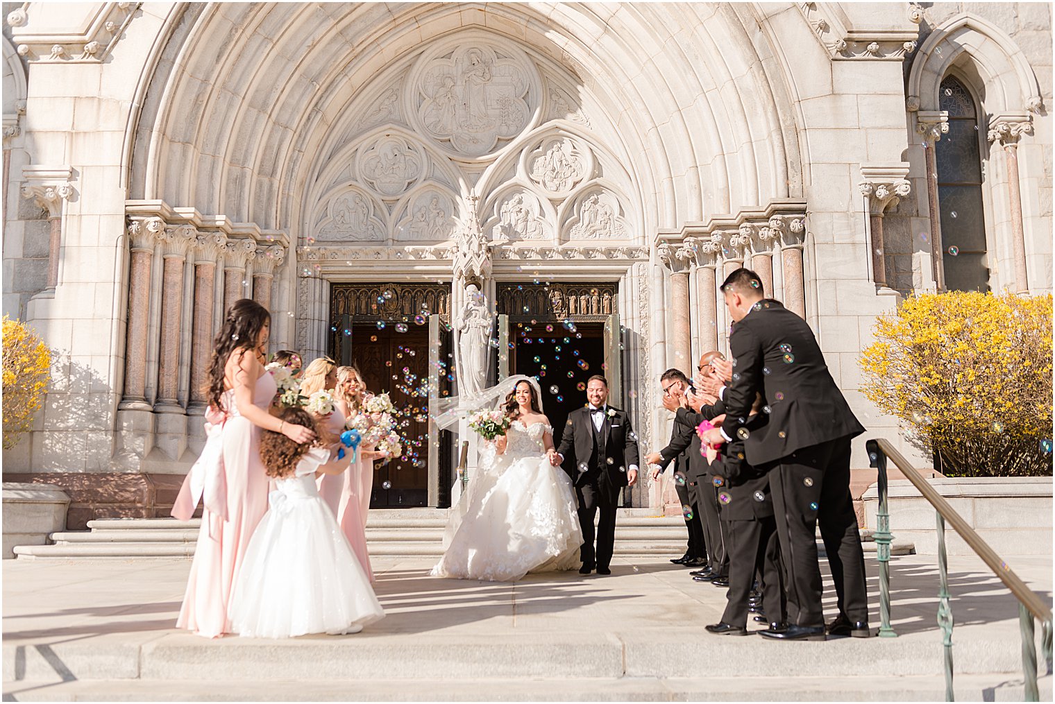 couple exits the Cathedral Basilica of the Sacred Heart with bubbles