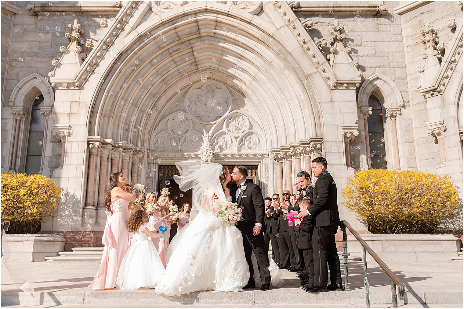 bride and groom kiss during exit outside the Cathedral Basilica of the Sacred Heart