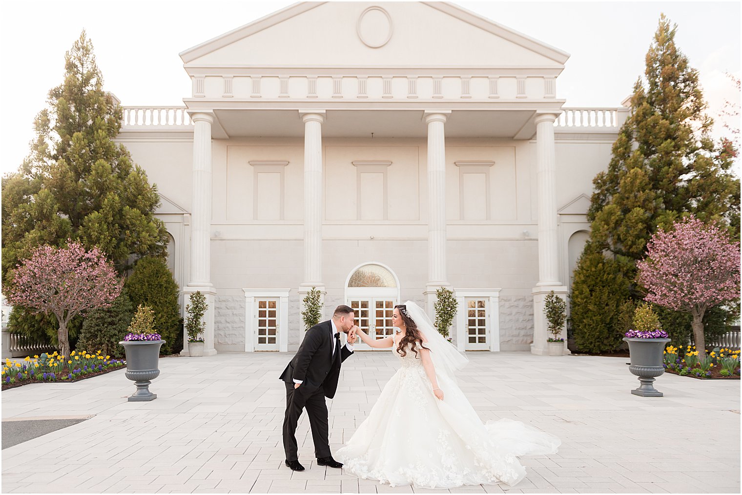 groom kisses bride's hand during NJ wedding day