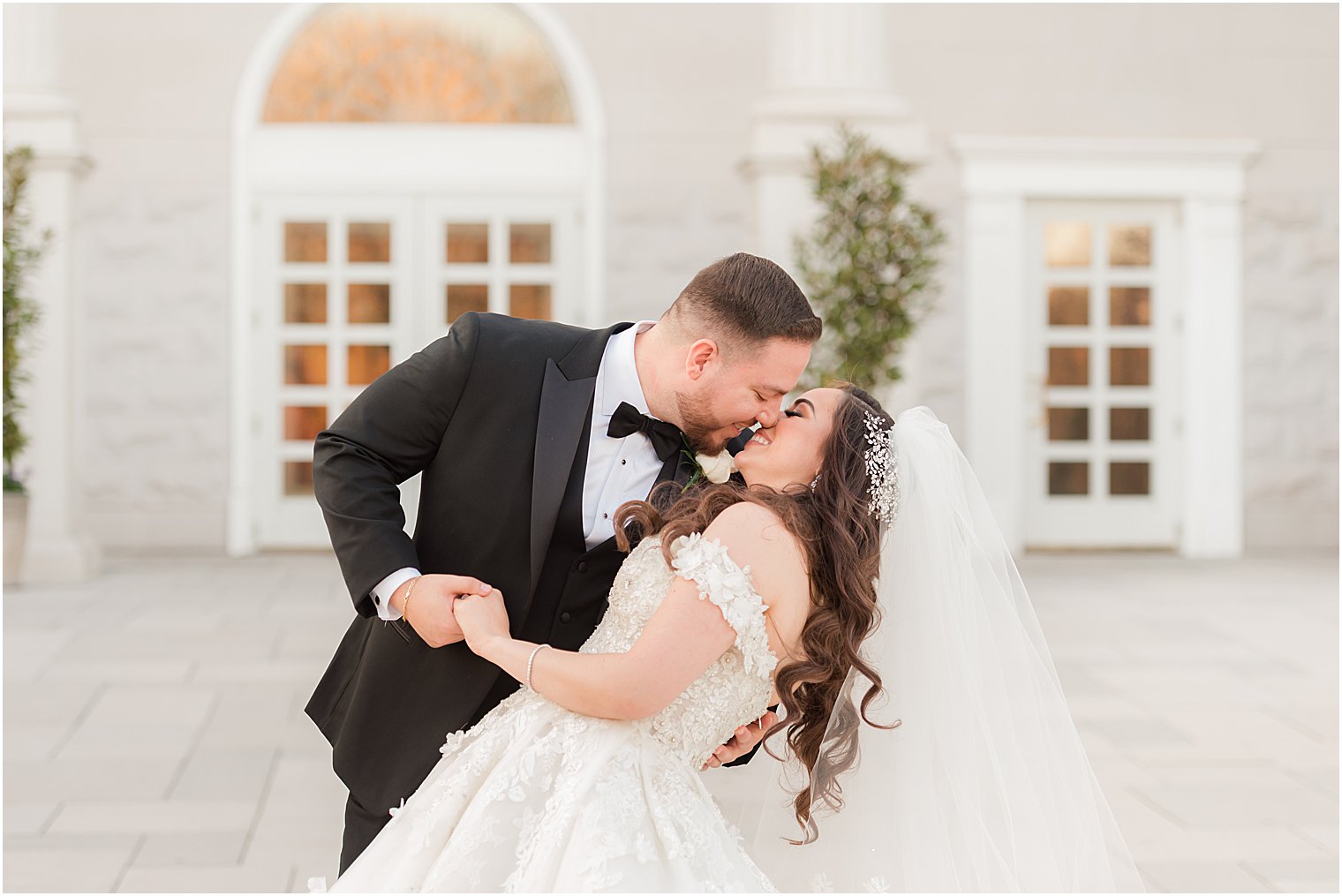 groom kisses bride dipping her outside The Palace at Somerset Park