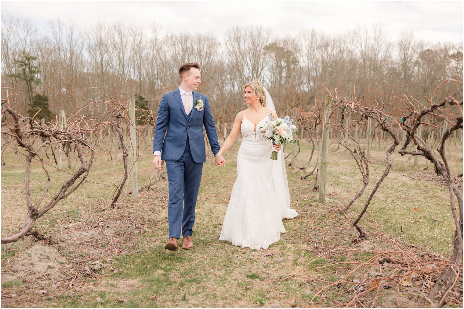 bride and groom walking in vineyards at Renault Winery in Egg Harbor Township, NJ