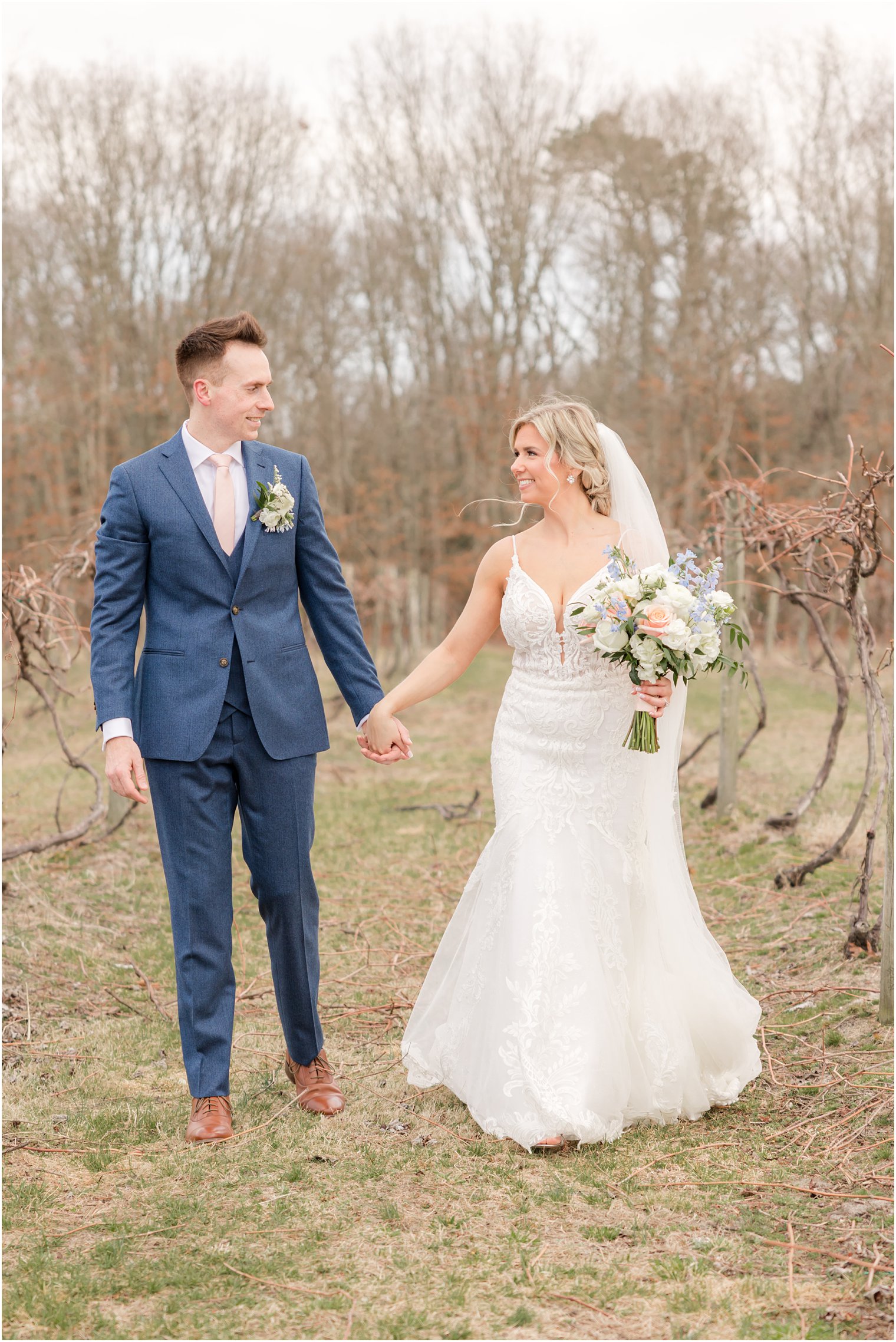 bride and groom walking through vineyards at Renault Winery in Egg Harbor Township, NJ