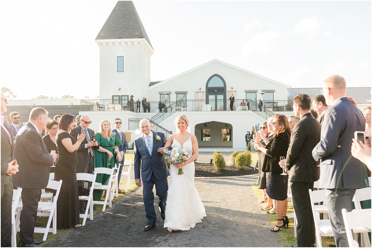 bride walking down the aisle with her father during outdoor ceremony at Renault Winery in Egg Harbor Township, NJ